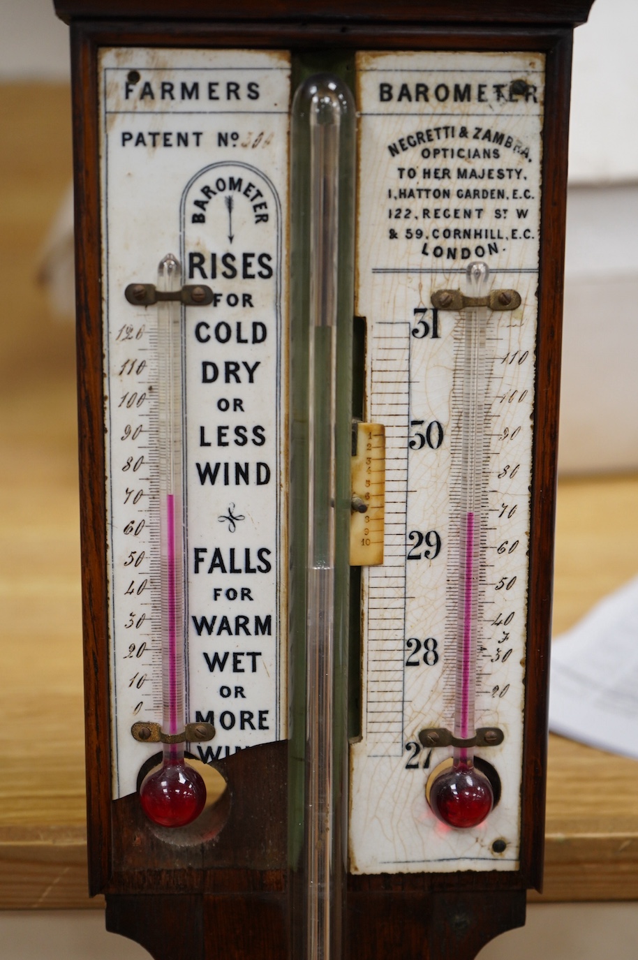 A Negretti and Zambra 'Farmer's' barometer, oak stick barometer with ceramic scales. Condition - fair, one scale broken with piece present.